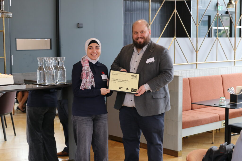 HAIC detupy director (on right) and the poster award winner holds the cerficate together.
